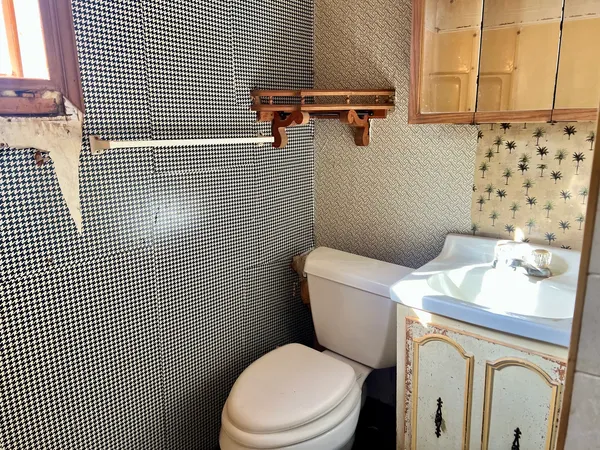 a white toilet sitting next to a bathroom sink