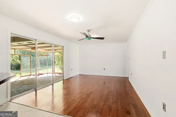 an empty room with wooden floor and windows