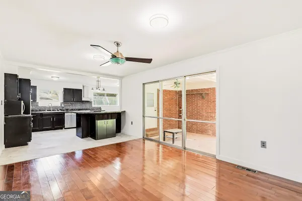 a view of a living room hardwood floor and a ceiling fan
