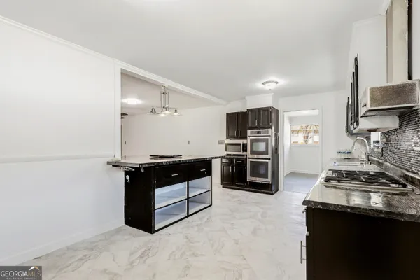 a kitchen with stainless steel appliances granite countertop a stove and a refrigerator