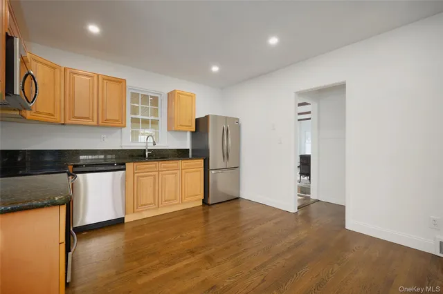 a kitchen with stainless steel appliances granite countertop a refrigerator and a stove top oven