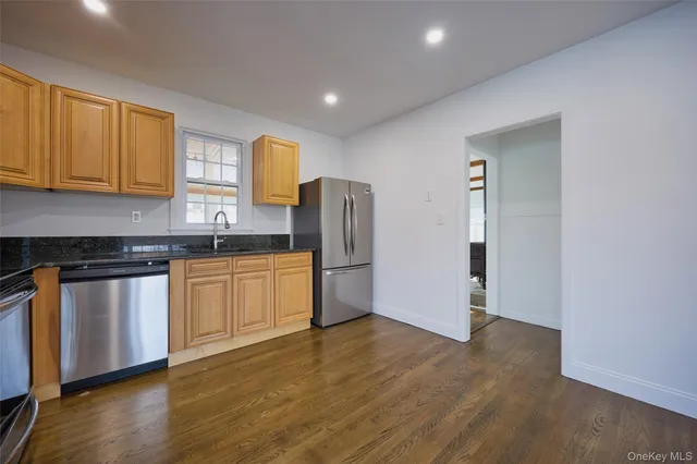 a kitchen with stainless steel appliances granite countertop a refrigerator and a stove top oven