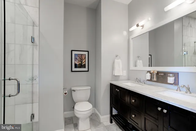 a bathroom with a double vanity sink toilet and a mirror