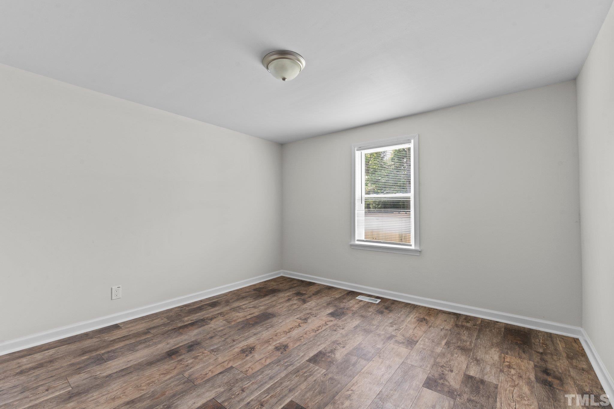 305 West Horton Street Zebulon, NC 27597 - Photo 11 of 29 wooden floor in an empty room with a window