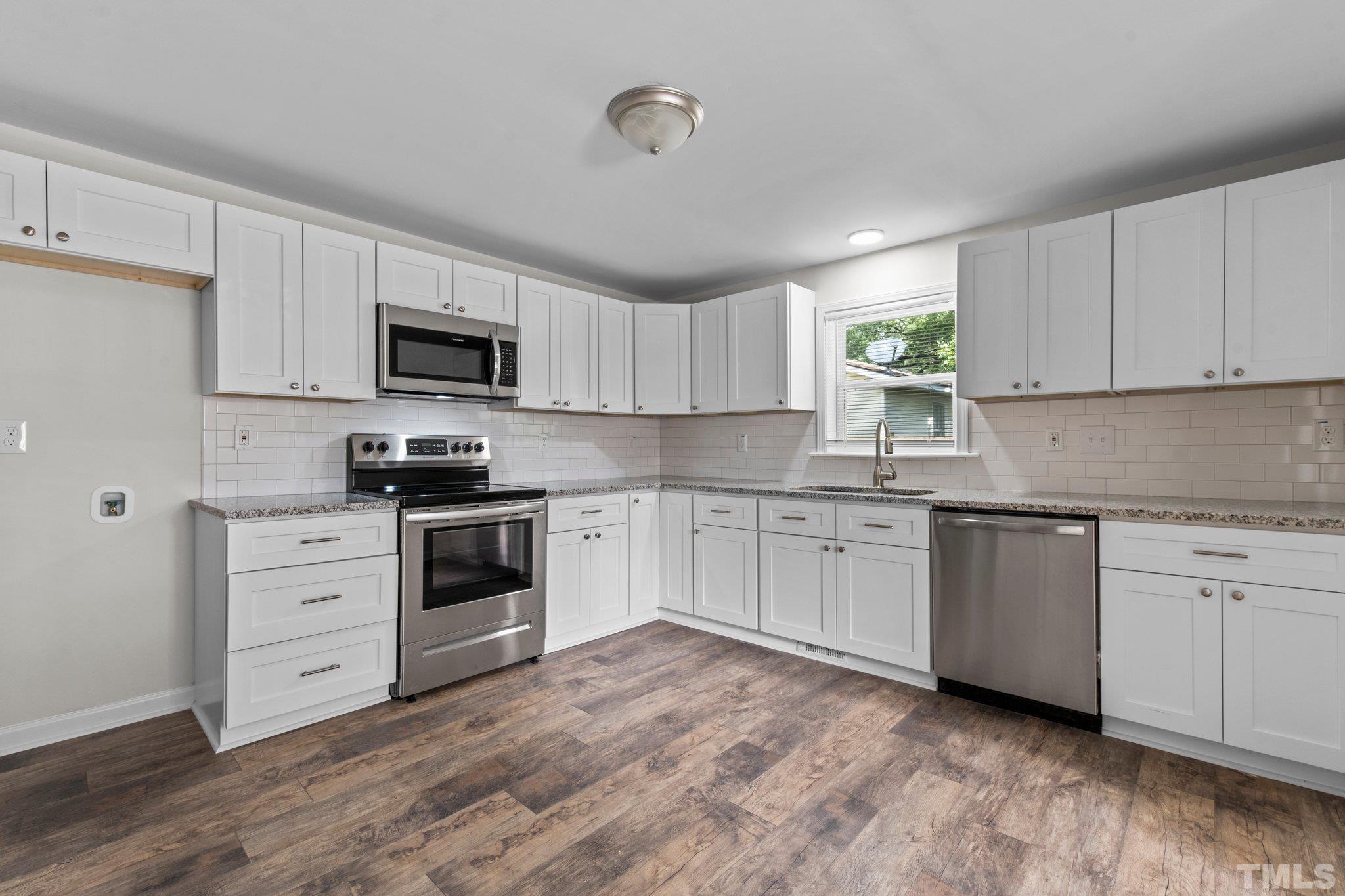305 West Horton Street Zebulon, NC 27597 - Photo 13 of 29 a kitchen with granite countertop white cabinets white stainless steel appliances and sink