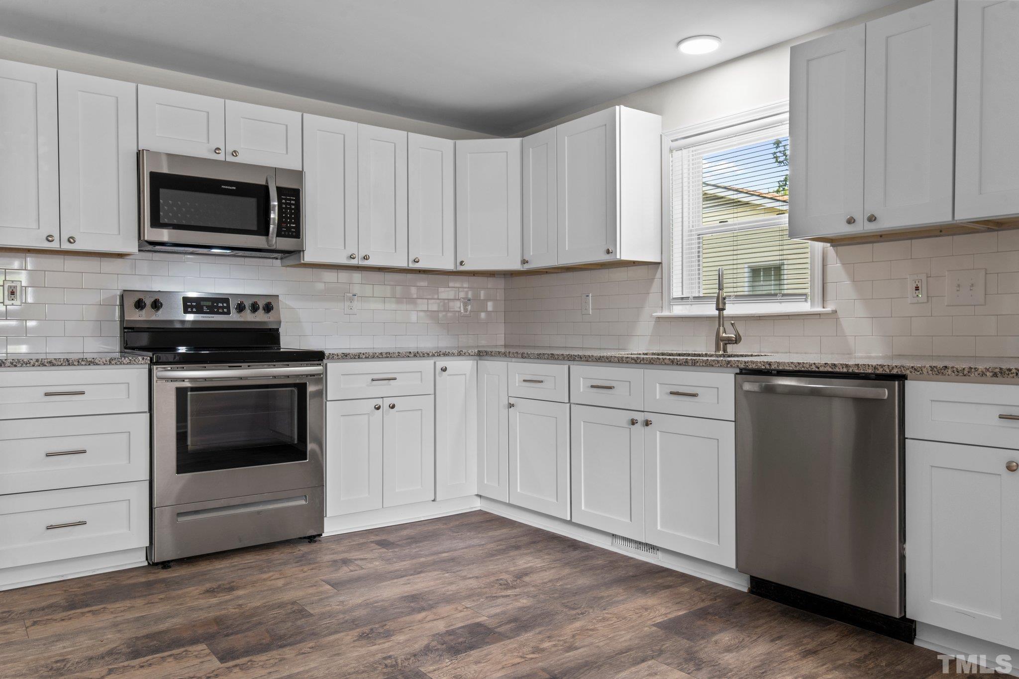 305 West Horton Street Zebulon, NC 27597 - Photo 14 of 29 a kitchen with granite countertop white cabinets and stainless steel appliances