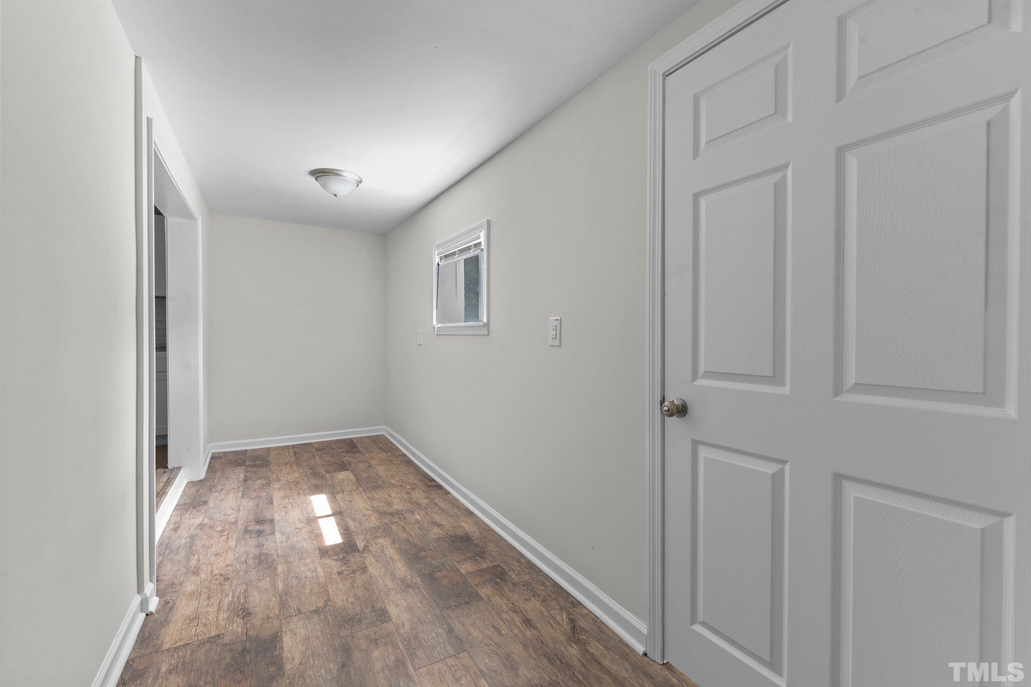 305 West Horton Street Zebulon, NC 27597 - Photo 15 of 29 an empty room with wooden floor and windows