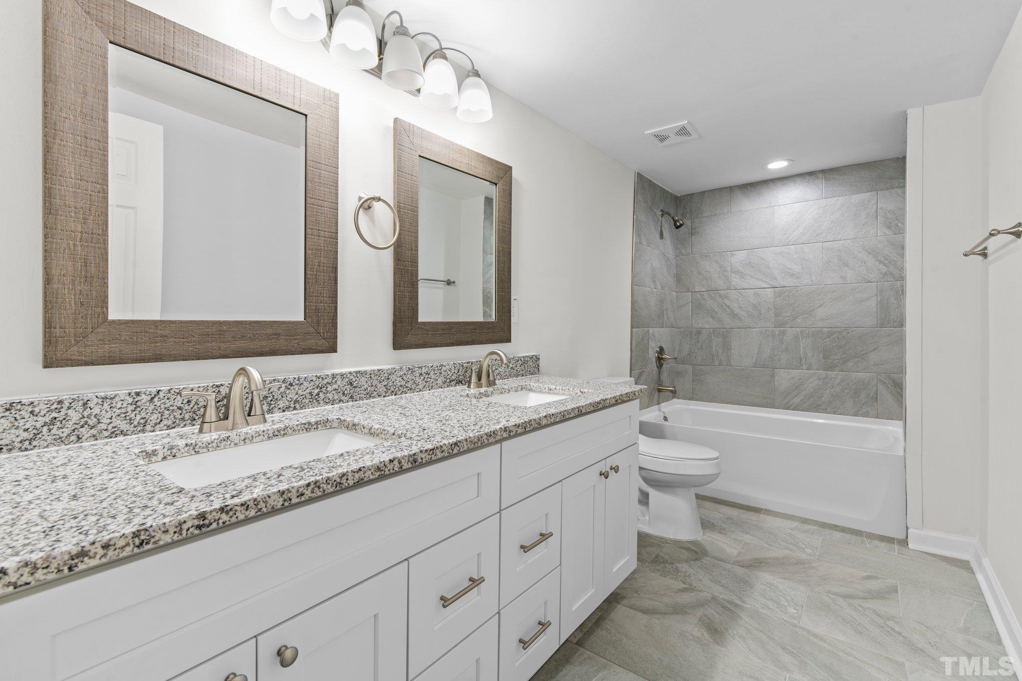 305 West Horton Street Zebulon, NC 27597 - Photo 16 of 29 a bathroom with a granite countertop sink mirror toilet and bathtub