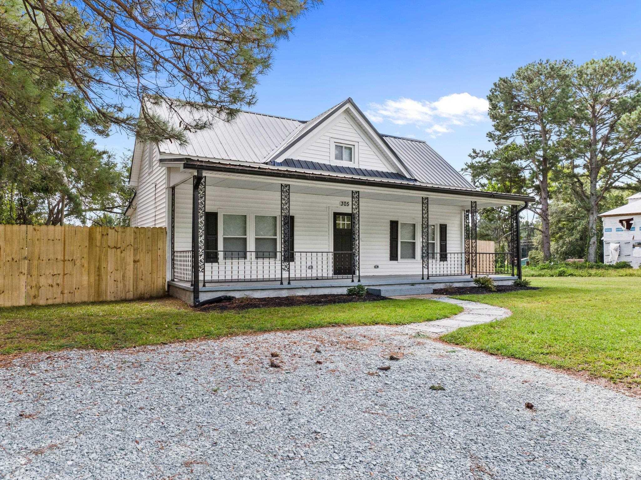 305 West Horton Street Zebulon, NC 27597 - Photo 2 of 29 a view of a white house with a swimming pool and a yard