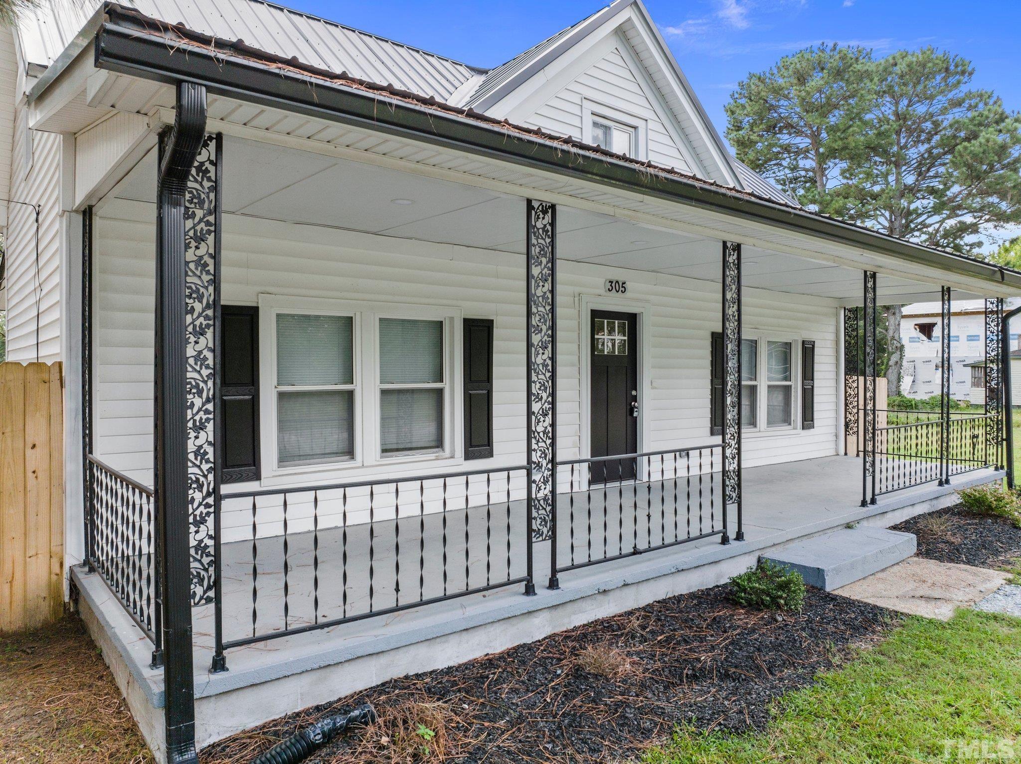 305 West Horton Street Zebulon, NC 27597 - Photo 4 of 29 a view of a house with a small yard and wooden floor and fence