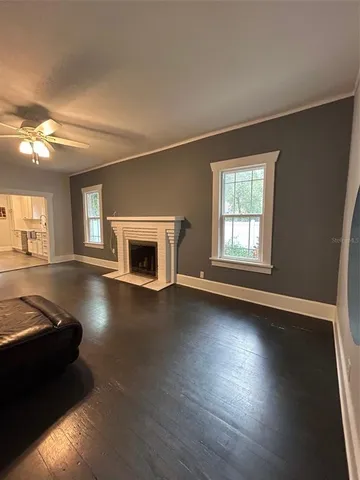wooden floor fireplace and windows in an empty room