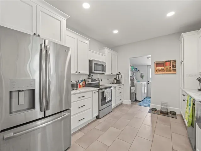 a kitchen with white cabinets and stainless steel appliances