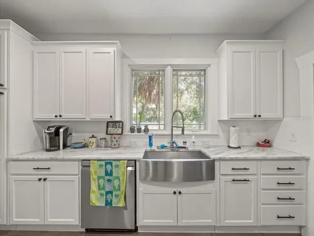 a kitchen with cabinets appliances a sink and a window