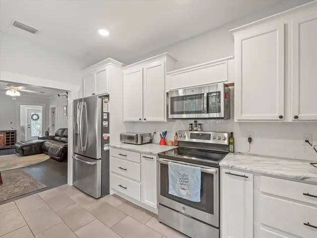 a kitchen with stainless steel appliances a stove microwave and refrigerator