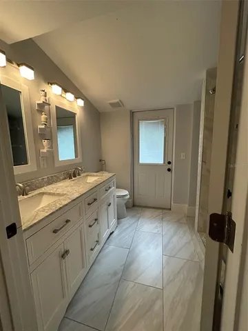a bathroom with a granite countertop sink mirror and bathtub
