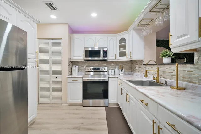 a kitchen with stainless steel appliances granite countertop a refrigerator sink and stove
