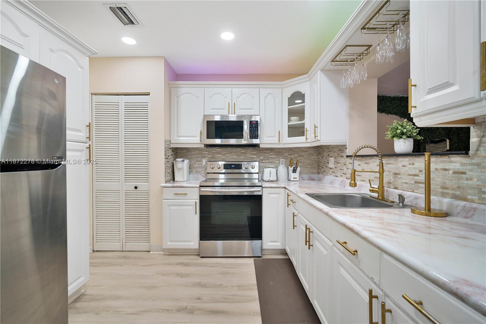 a kitchen with stainless steel appliances granite countertop a refrigerator sink and stove