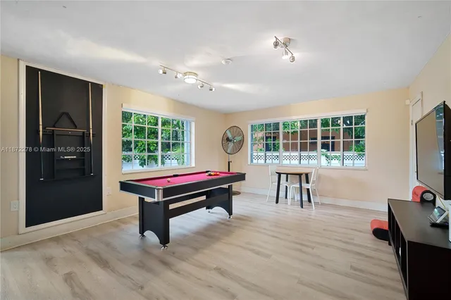 a living room with a flat screen tv and pool table