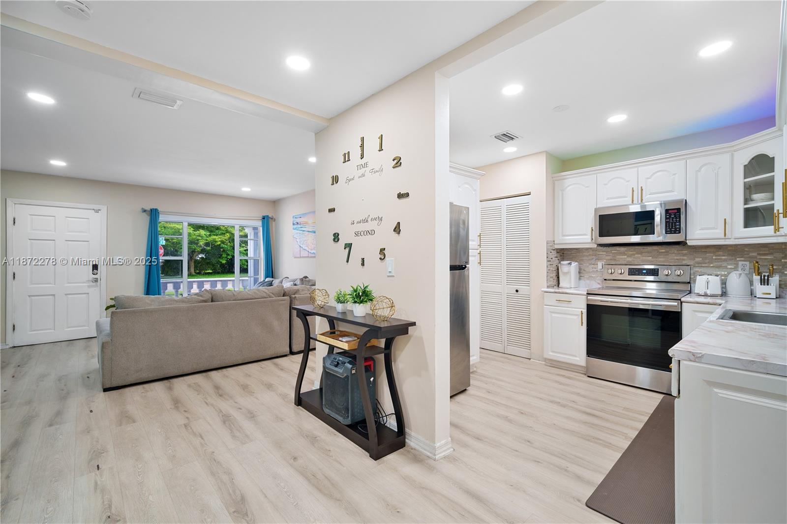 951 Northwest 148th Street Miami, FL 33168 - Photo 19 of 34 a kitchen with furniture a large window and stainless steel appliances