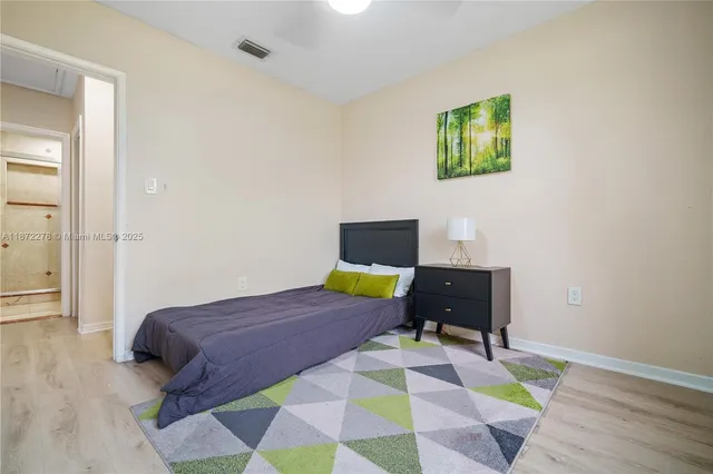a bedroom with a bed and a potted plant