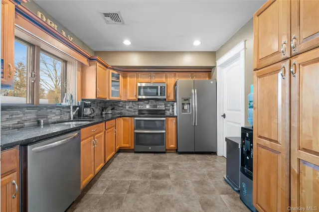 a kitchen with stainless steel appliances granite countertop a refrigerator and a sink