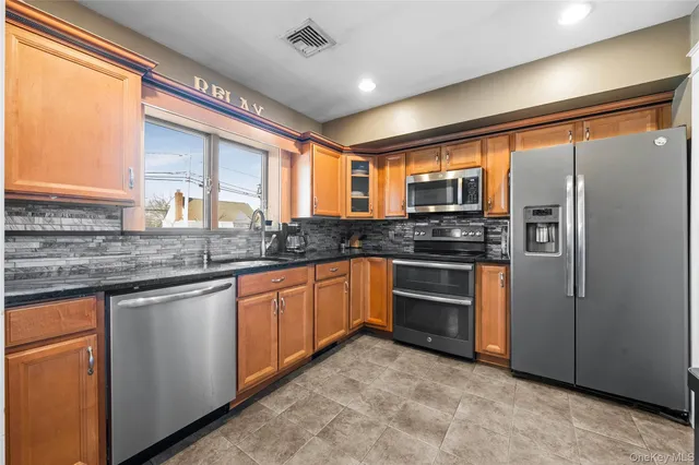 a kitchen with stainless steel appliances granite countertop a stove refrigerator sink and microwave