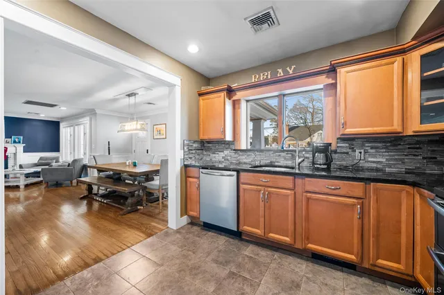 a kitchen with stainless steel appliances granite countertop sink stove and white cabinets