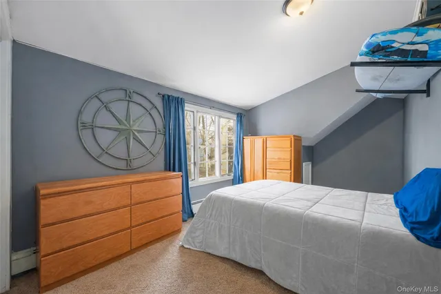 a bedroom with a bed a window and dresser