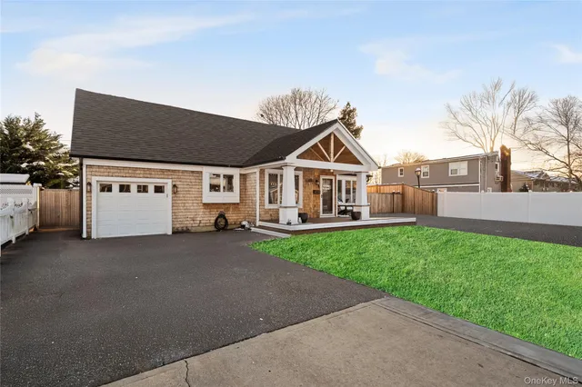 a view of a white house with a big yard and large trees