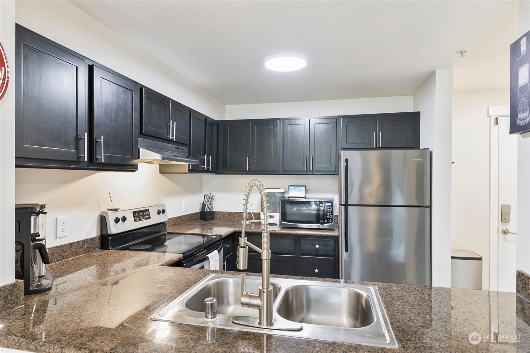 16409 Currie Road Southeast, Unit 305 Monroe, WA 98272 - Photo 3 of 23 a kitchen with granite countertop a refrigerator and a sink