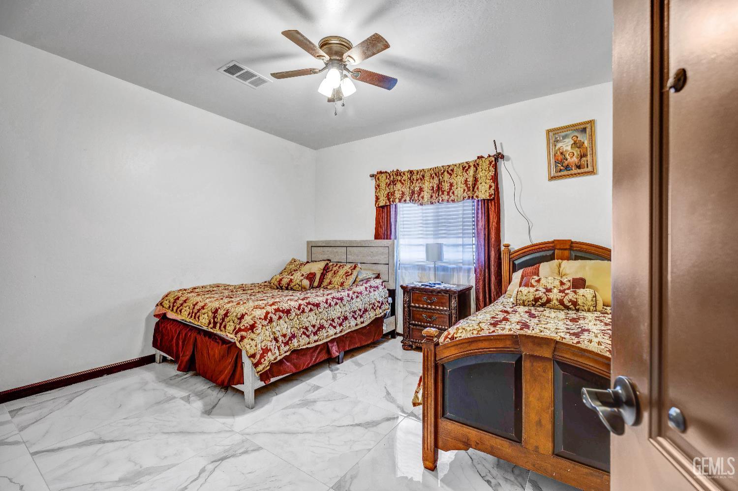 Undisclosed Address Taft, CA 93268 - Photo 21 of 43 a bedroom with two beds and a chandelier