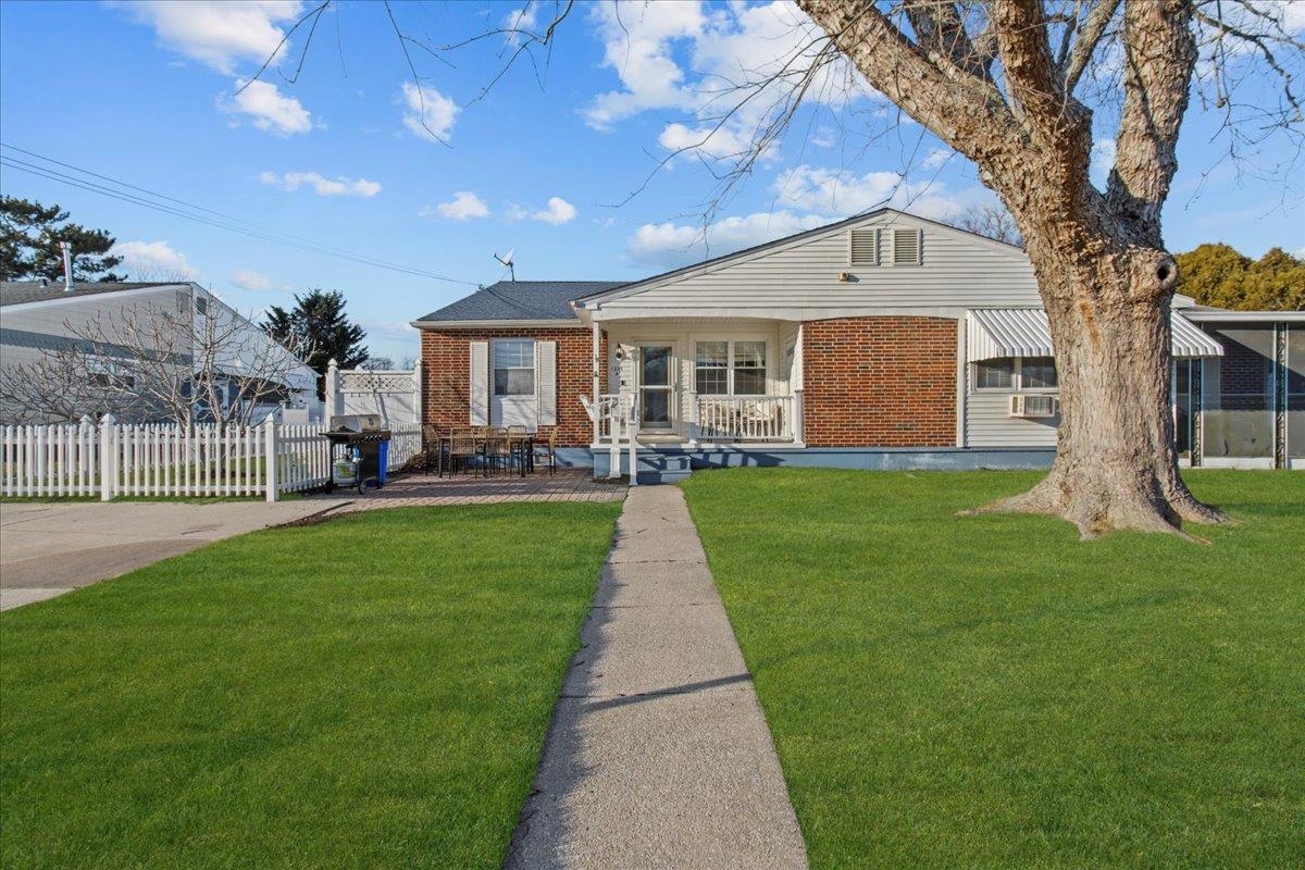 a front view of a house with a yard and trees