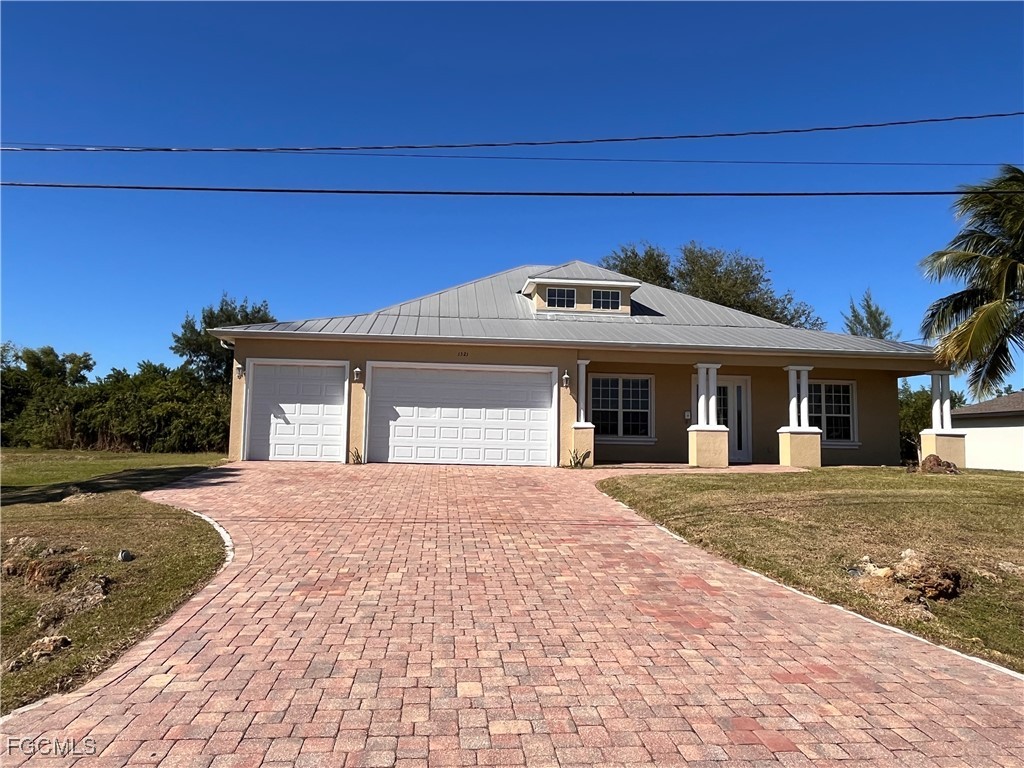a front view of a house with a yard and a garage