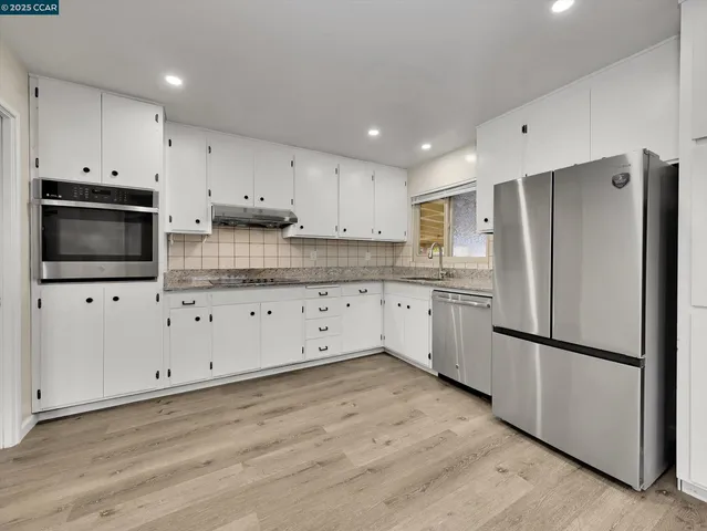 a kitchen with granite countertop a stove sink and cabinets