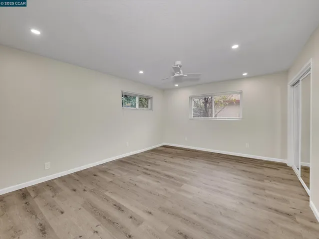 an empty room with closet and windows