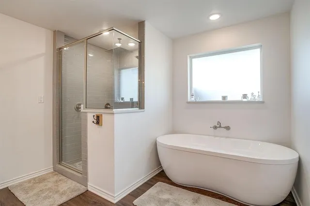 a bathroom with a white tub shower and sink