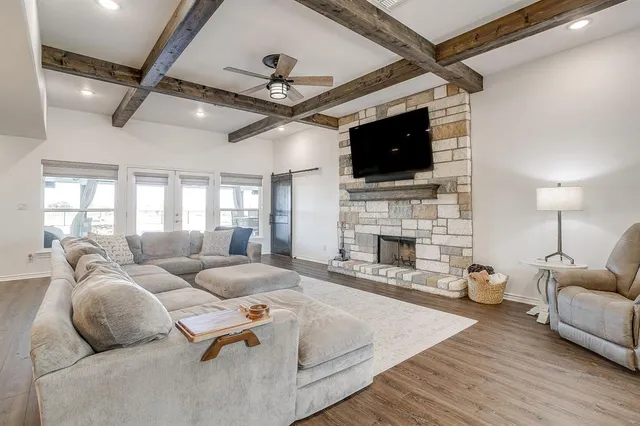 a living room with furniture a fireplace and a flat screen tv