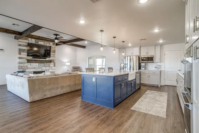 a large kitchen with stainless steel appliances sink a microwave and cabinets