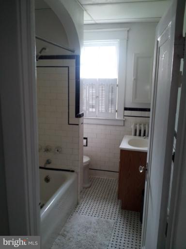 624 Stamford Road Baltimore, MD 21229 - Photo 12 of 21 a bathroom with a sink a bathtub and a window
