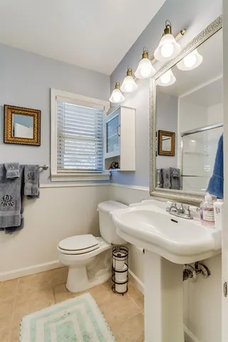 a bathroom with a sink toilet and a mirror