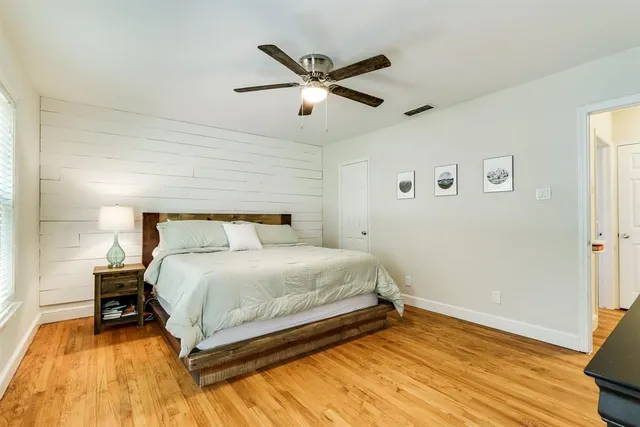 a bedroom with a bed and wooden floor