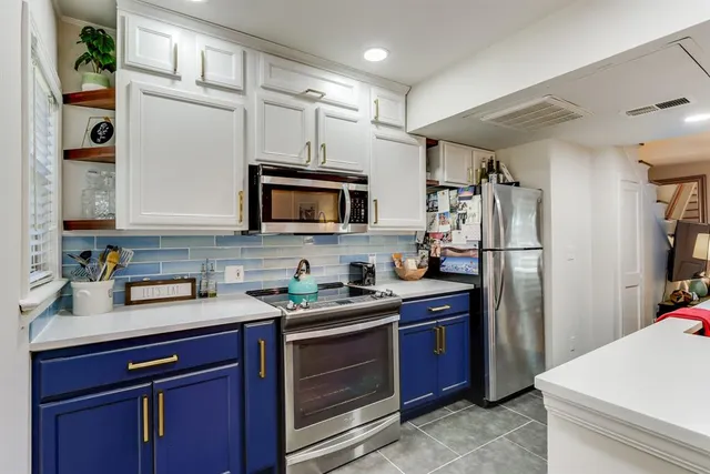 a kitchen with stainless steel appliances granite countertop a refrigerator stove and sink