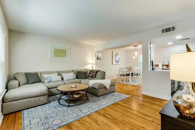 a living room with furniture a rug and a table