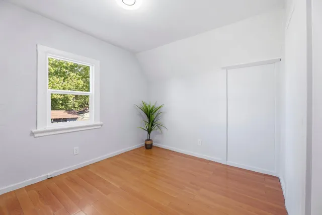 an empty room with a window and wooden floor