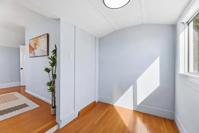 a view of a bedroom with wooden floor and small space
