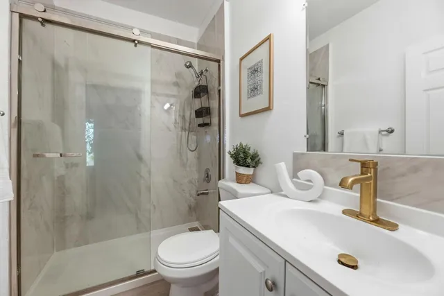 a bathroom with a sink toilet and shower