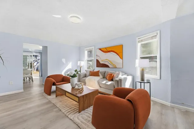 a living room with furniture a flat screen tv and a window