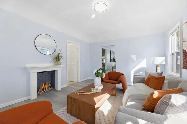a living room with furniture a fireplace and a chandelier
