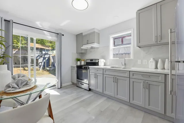 a kitchen with granite countertop white cabinets and white appliances