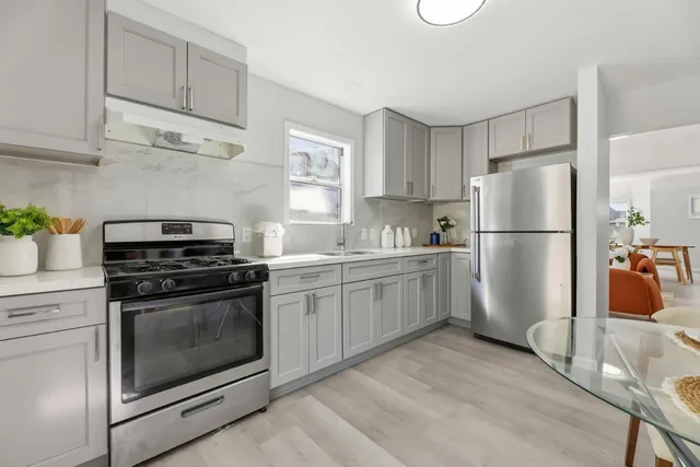 a kitchen with a refrigerator stove and white cabinets